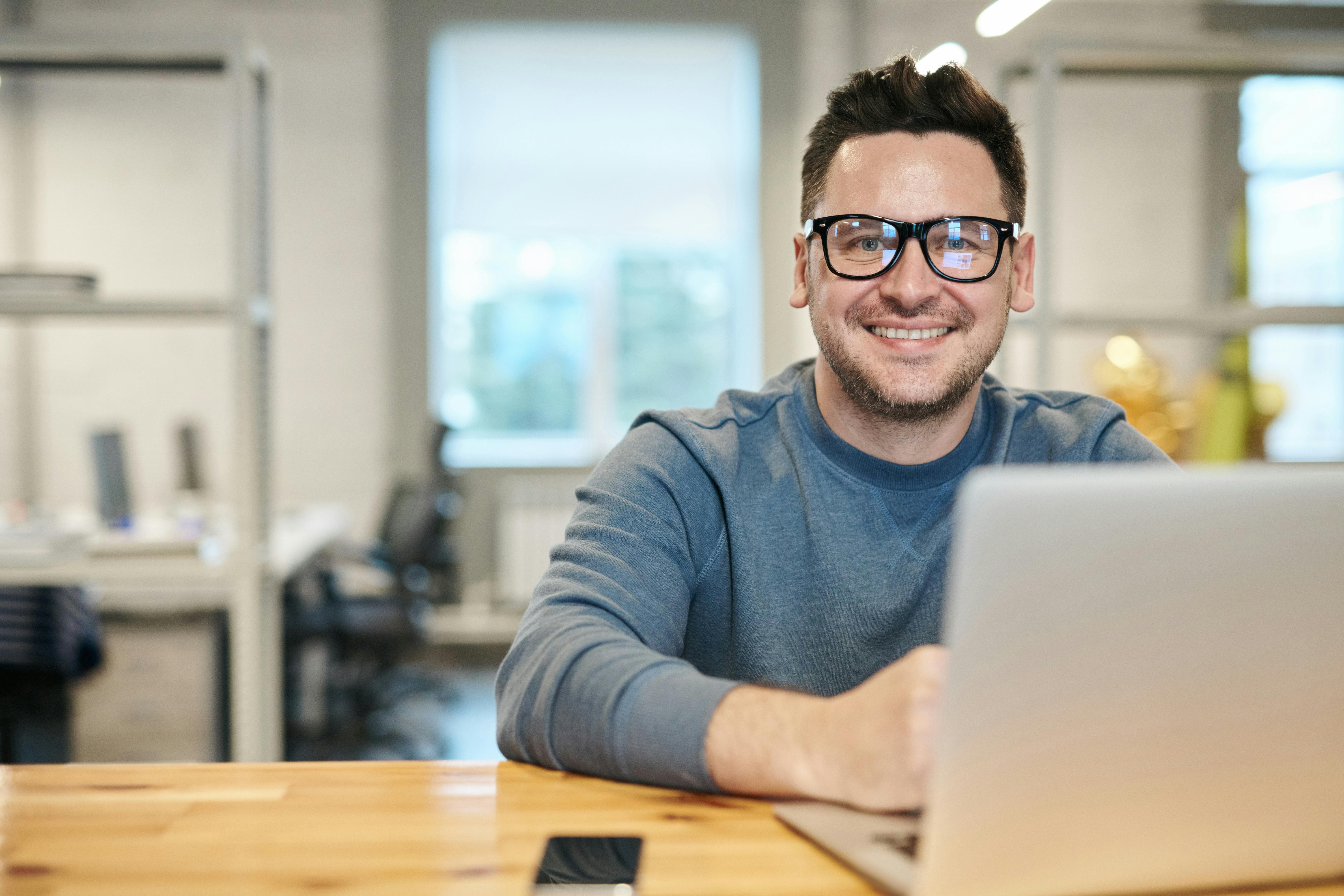 School administrator smiling while managing bookings on MagicBooking at a laptop
